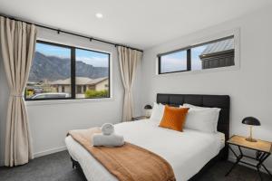 a bedroom with a bed and a large window at Mountain Escape by Remarkables 9 | 2-bedroom unit in Frankton Wharf