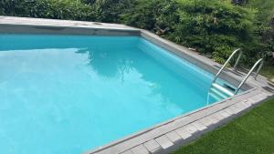 a large blue swimming pool with two chairs in it at villa Marta e Martino in Lugano