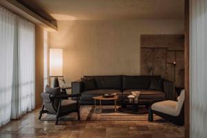 a living room with a couch and a table and chairs at Shaxi Senxi Aesthetic Art Boutique Homestay in Diannan