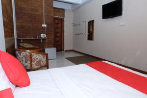 a bedroom with a bed and a tv on the wall at OYO 1017 Al-inshirah Inn in Kota Bharu