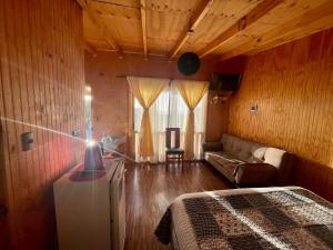 a bedroom with a bed and a couch in a room at Apartamento en Playa Hermosa, Pichilemu - Cabañas Parova in Pichilemu