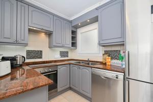 eine Küche mit weißen Schränken und einem Edelstahlkühlschrank in der Unterkunft Hawaii in Jávea