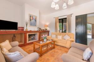 Una sala de estar con sofás y chimenea. en Villa Durán, en Cantillana