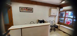 a kitchen with a counter and chairs in a room at Hotel BMR Stay in Pollāchi