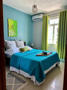 a blue bedroom with a bed with a blue blanket at Flic en Flac Beachfront Apartment, KAZAFIBI in Flic-en-Flac