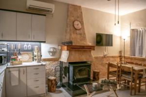 a kitchen with a fireplace and a table in it at Taygetos Escape Sparta in Perivólia