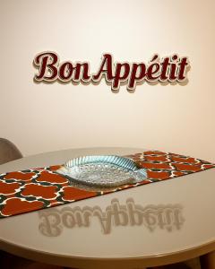 a table with a plate on top of it with a sign at White Homes Apartments • Central Point in Podgorica