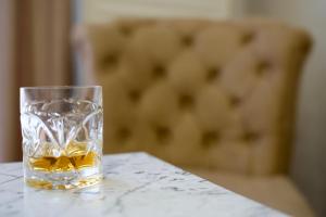 a glass of whiskey sitting on a table at Panorama - 1 Lazarevac in Lazarevac