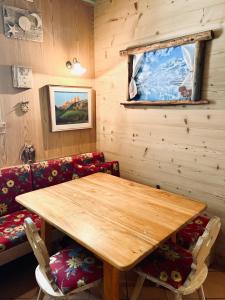 a dining room with a wooden table and chairs at B&B Col Da La Vila in Canazei +34 photos