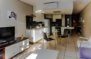 a kitchen with a living room and a dining room at Modern Sunny De Waterkant Studio in Cape Town