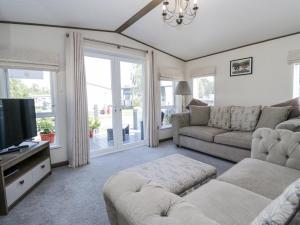 un salon avec un canapé et une télévision dans l'établissement Lilac Lodge, à Carnforth