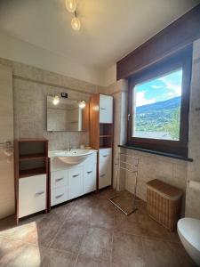 Un baño con lavabo y una gran ventana. en HabitAlp360, en Roisan