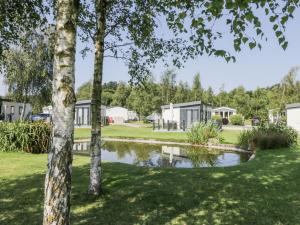 une vue d'un parc avec des maisons et un étang dans l'établissement Lilac Lodge, à Carnforth