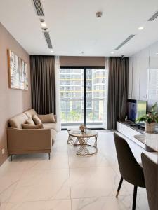 ein Wohnzimmer mit Sofa und Tisch in der Unterkunft The Place-Vinhome-Gold in Gò Công