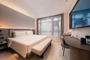 a bedroom with a large white bed and a desk at Atour Light Hotel Beijing Wukesong 301 PLA Hospital in Beijing +45 photos