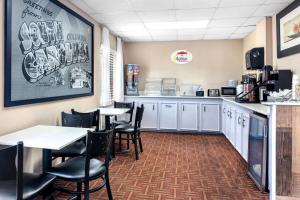 a restaurant with tables and chairs and a counter at Super 8 by Wyndham Columbia in Columbia