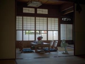 a room with a table and chairs and windows at 自去来 in Hayashima