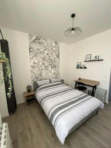 a large bed in a room with a table at Chez Jules, appartement tout confort de 40 m2 in Denain