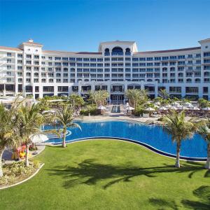 a resort with a large swimming pool and palm trees at Waldorf Astoria Dubai Palm Jumeirah in Dubai