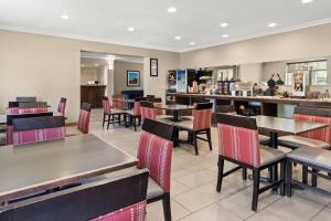 a restaurant with tables and chairs and a bar at Comfort Inn & Suites Lancaster Antelope Valley in Lancaster