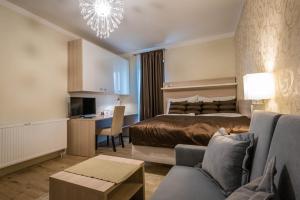 ein Hotelzimmer mit einem Bett, einem Sofa und einem Tisch in der Unterkunft Vila Monika in Tvrdošovce