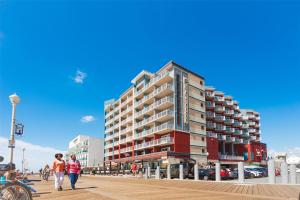 two people walking on a boardwalk in front of a building at Hyatt Place Ocean City Oceanfront in Ocean City