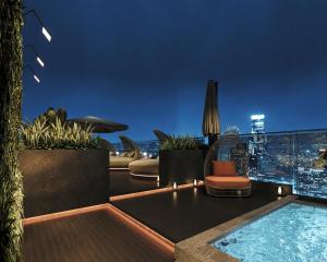 a rooftop patio with a swimming pool at night at L'Heritage Premium Hanoi Central in Hanoi