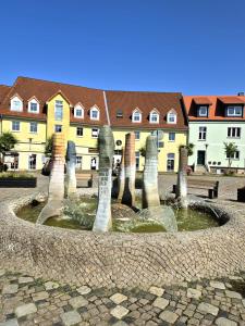 a fountain in the middle of a courtyard with houses at Ferienidyll an der Recknitz in Tessin