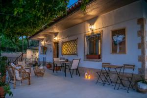 a patio with tables and chairs next to a building at Taygetos Escape Sparta in Perivólia