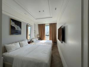 a hotel room with two beds and a television at Green PT Boutique Seaview Hotel in Phu Quoc