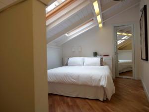 una camera da letto con un grande letto bianco e una finestra di Ferrini Home - Piazza Trento a Catania Altre 22 foto