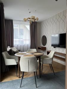 a living room with a table and chairs and a tv at Białe Wierchy Kościelisko in Witów