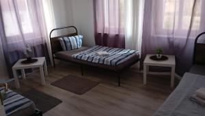 a small room with a bed and two tables at Stellas Monteurwohnungen in Crimmitschau