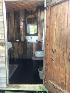 an open door to a bathroom in a wooden house at Yourte Les Hulottes en Comminges in Juzet-dʼIzaut +16 photos