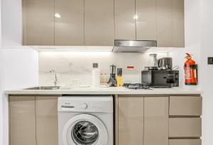 eine Küche mit Waschmaschine und Spüle in der Unterkunft Elegant Studio with Pool Access & Private Terrace in Dubai