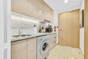 eine Küche mit Waschmaschine und Spüle in der Unterkunft Elegant Studio with Pool Access & Private Terrace in Dubai