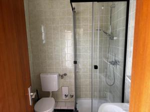 a bathroom with a shower with a toilet and a sink at Campingplatz Weserterrassen Polle in Polle