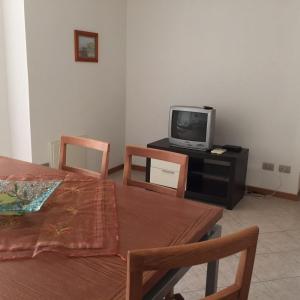 ein Esszimmer mit einem Tisch und einem TV in der Unterkunft Bertolottu Residence Apartments in Tortolì