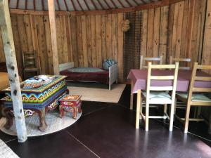 a room with a table and chairs and a bed at Yourte Les Hulottes en Comminges in Juzet-dʼIzaut