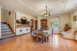 Una cocina y una sala de estar con mesa y sillas. en Villa Miriam, en El Padul