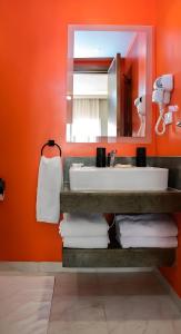 a bathroom with a sink and a mirror and towels at Fanadir Suite All inclusive Resort in Hurghada