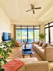 a living room with a couch and a ceiling fan at Villa Dauphin in Grand Baie