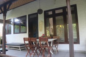 a table and chairs on the porch of a house at villa Philippe Mimpi 19 in Jasri