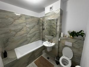 a bathroom with a tub and a toilet and a sink at Great View & Parking - Harmony Premium Residence in Timişoara +23 photos