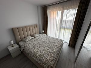 a bedroom with a bed and a large window at Great View & Parking - Harmony Premium Residence in Timişoara