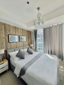 a bedroom with a large white bed and a window at The Suites Residences, Azure Luxury Resort, Manila Airport, Wave-Pool, Tropical Vibes in Manila