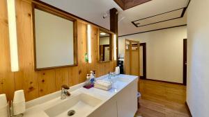 a bathroom with a white sink and a mirror at Pension Eastmountain Hakuba in Hakuba +142 photos