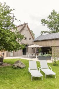 OberndorfにあるDesign-Landhaus BunnyHuus - gesamtes Hausの建物の前の芝生に置かれた2つの白い椅子