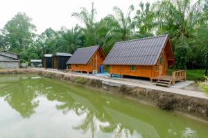 due capanne di legno accanto a uno specchio d'acqua di Legend muay thai gym a Ban Nong Chaeng
