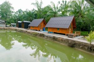 due case accanto a uno specchio d'acqua di Legend muay thai gym a Ban Nong Chaeng